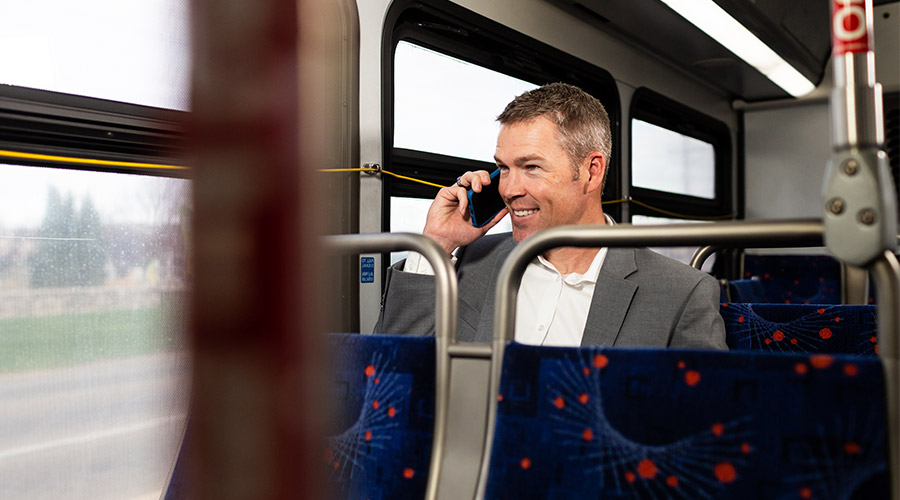 Business talking on his cell phone while riding the bus